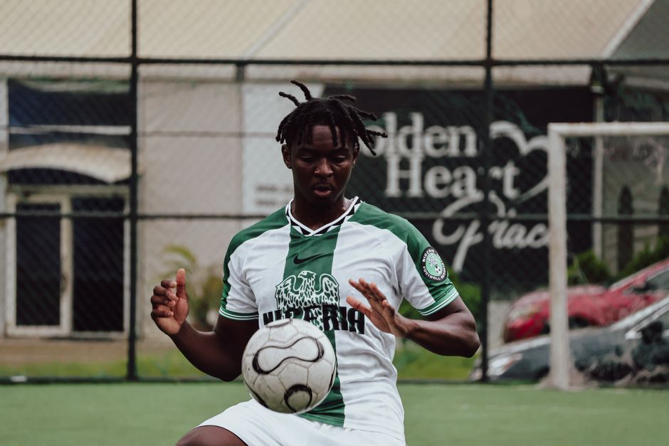 Um atleta em pé sobre uma montanha-russa de obstáculos, com um livro de autoajuda aberto ao lado
