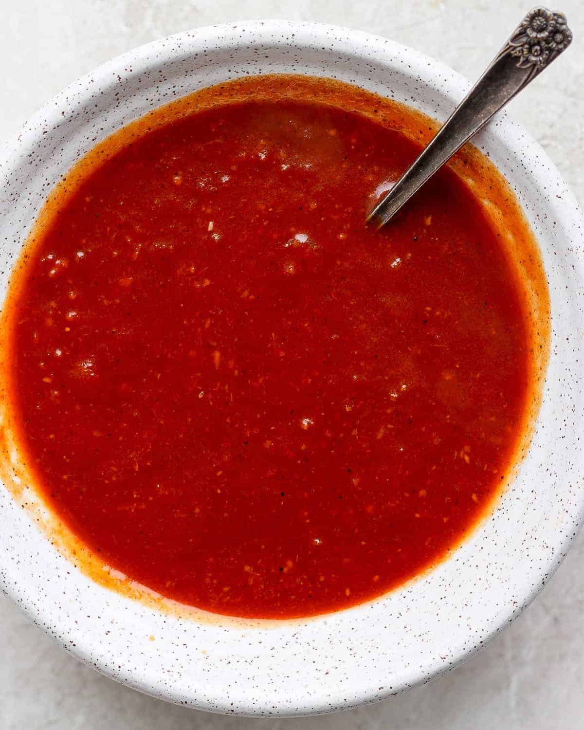 Uma pessoa preparando molho caseiro em uma panela com ingredientes frescos e vegetais