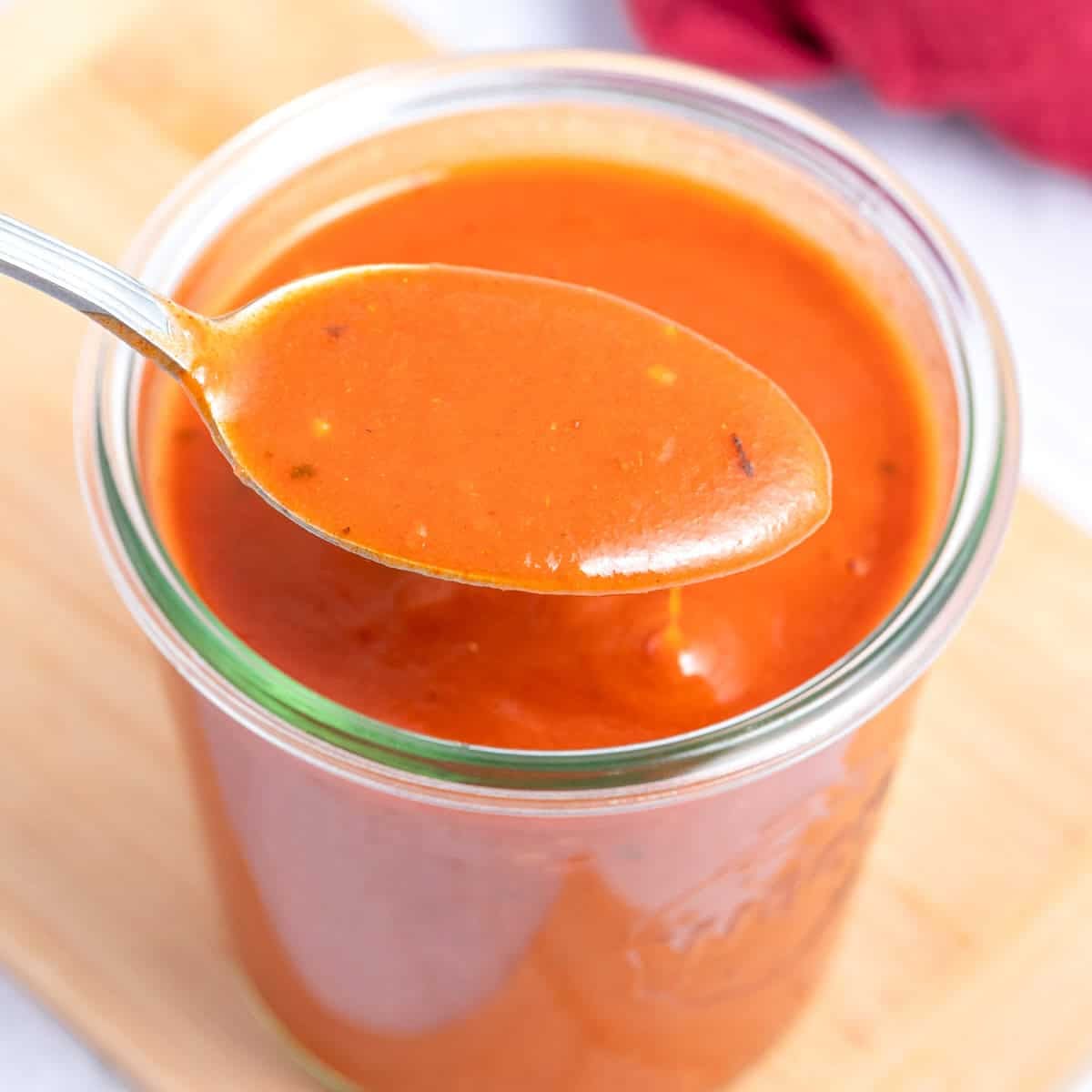 Uma pratos de tacos recheados com carne e vegetais, acompanhados de um molho vermelho quente e espesso