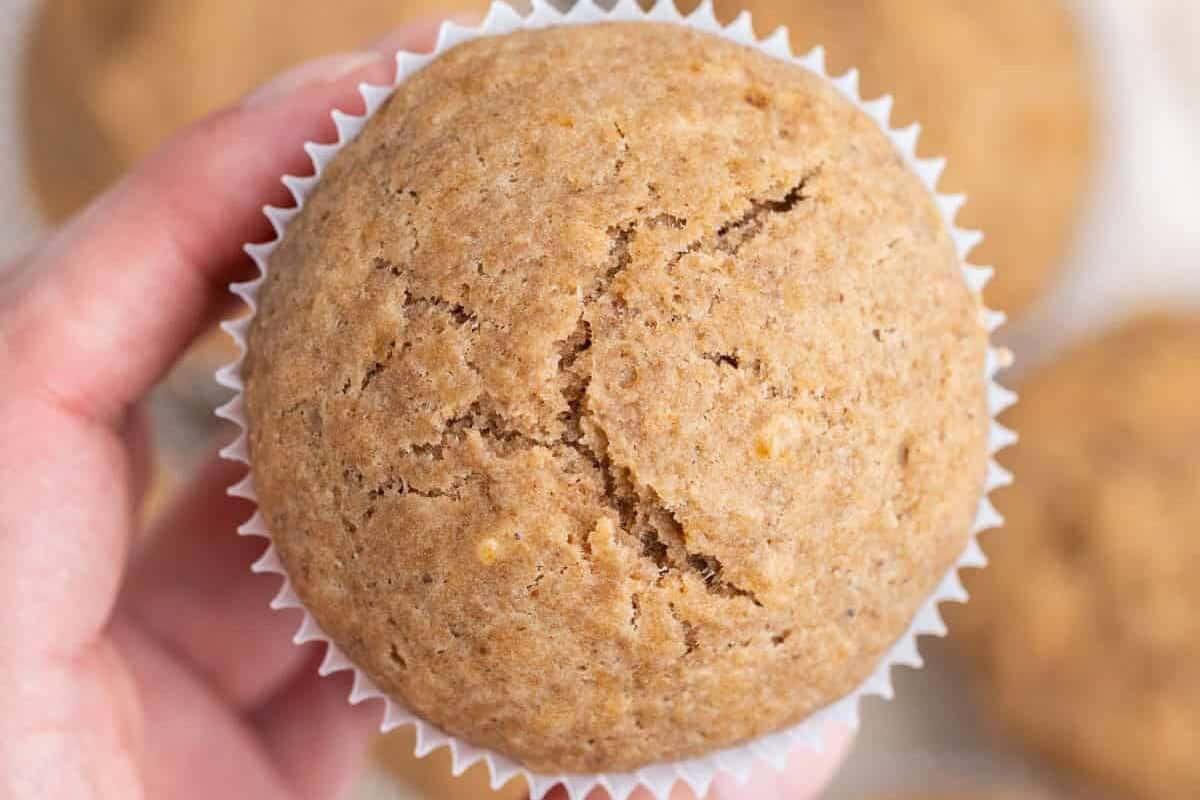 Muffins de maçã dourados em prato rústico, acompanhados de chá verde e uma faixa de exercício leve ao fundo