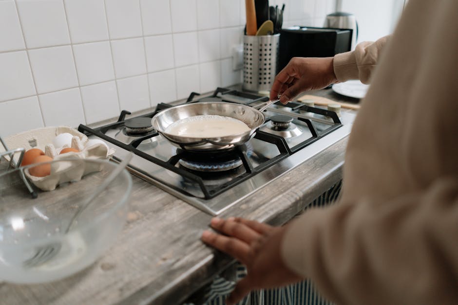 Omelete dourada e fofinha servida em prato branco, acompanhada de espinafre fresco e ovos inteiros sobre uma bancada
