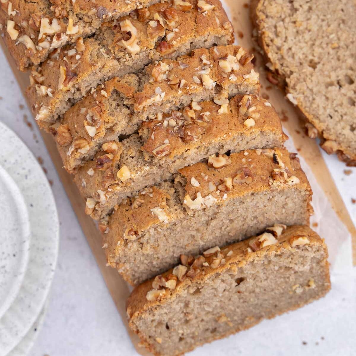Um pão de maçã assado com fatias de frutas e um prato de iogurte grego ao fundo