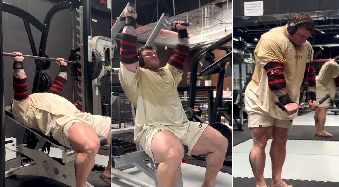 Homem musculoso executando supino inclinado na Smith machine, com halteres ao lado e barra de pushdown ao fundo