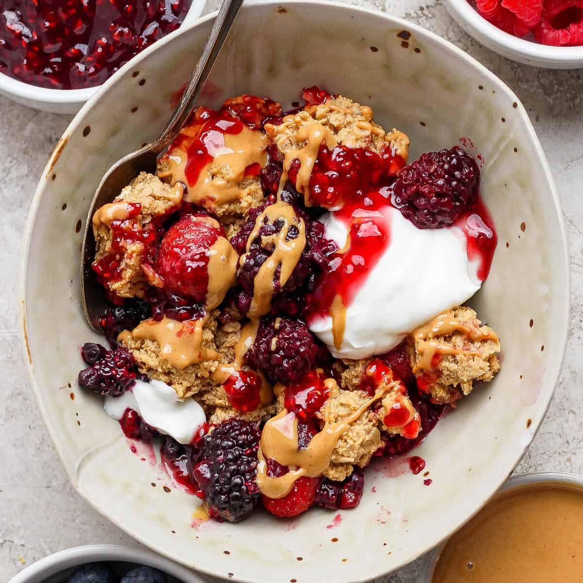 Frutas congeladas e manteiga de amendoim com proteína espalhada sobre uma tigela de açaí