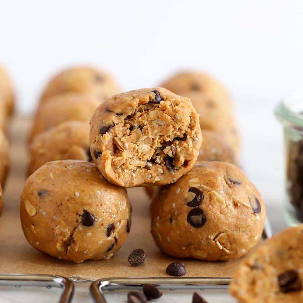 Um prato com uma bola de peanut butter protein feita com aveia, nozes e proteína em pó, sobre uma toalha de mesa branca
