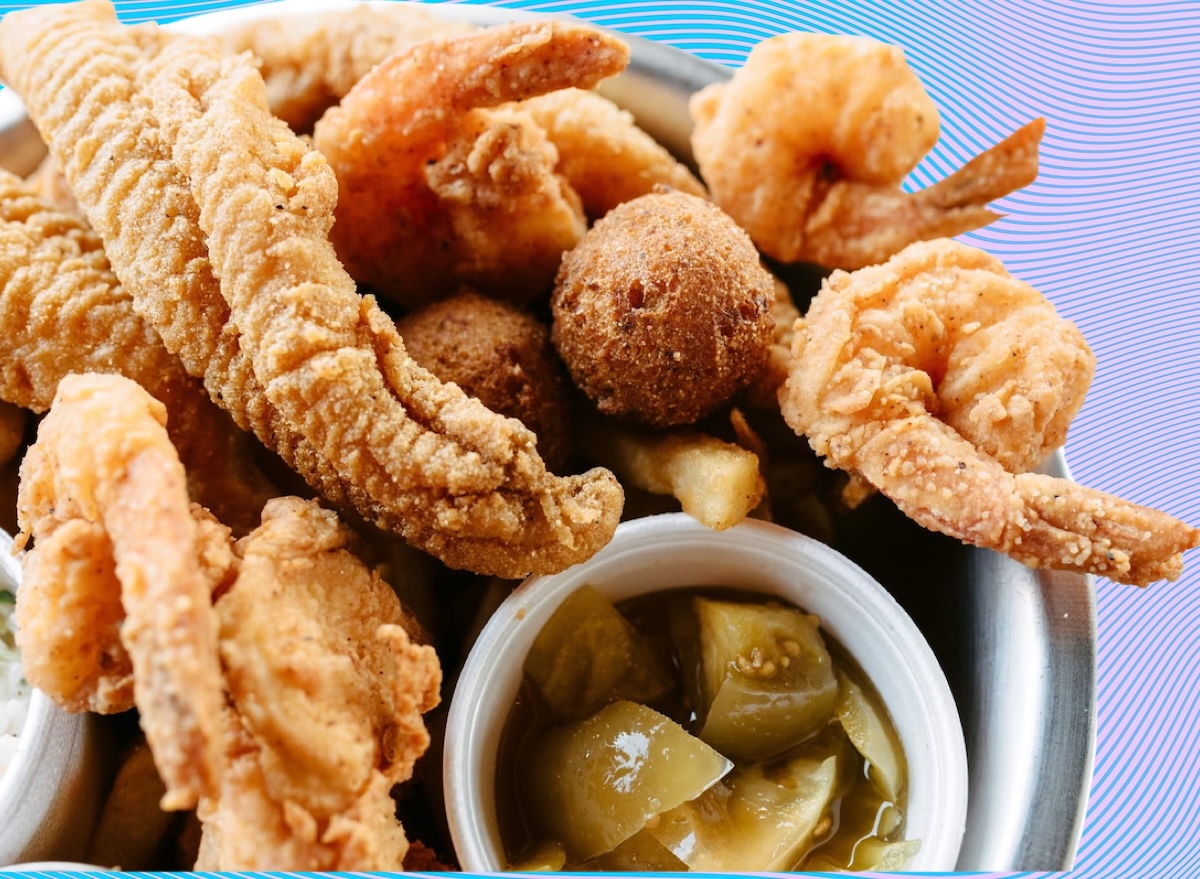 Um prato de frutos do mar recheado com camarão, salmão e peixe grelhado, servido com salada de folhas verdes e legumes frescos