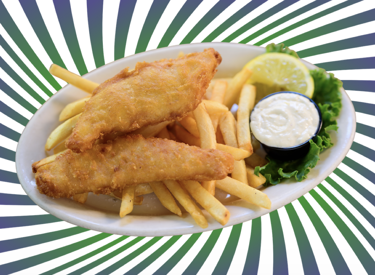 Um peixe congelado fresco, com filés inteiros e verdejante, ao lado de frutas cítricas e folhas de alface