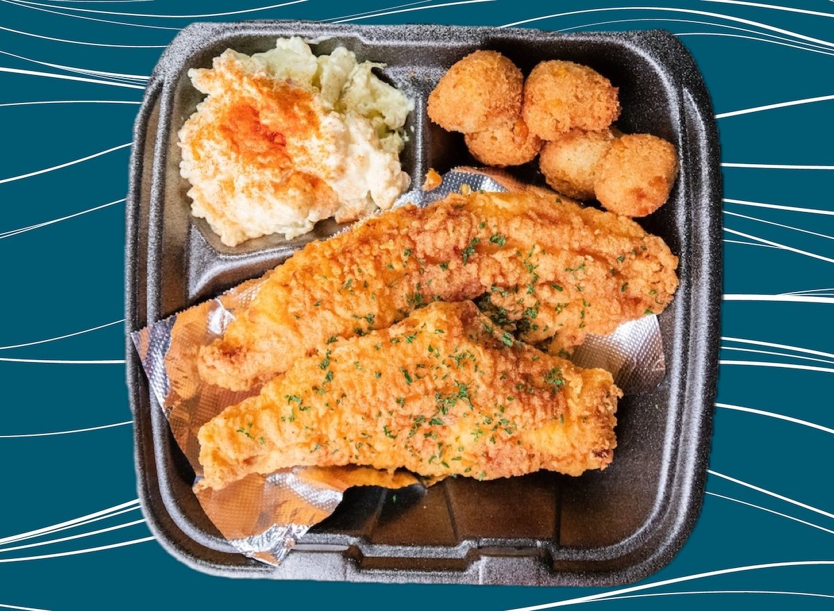 Filés de peixe dourados ao lado de salada cremosa de batata, com pimentão vermelho e folhas verdes frescas