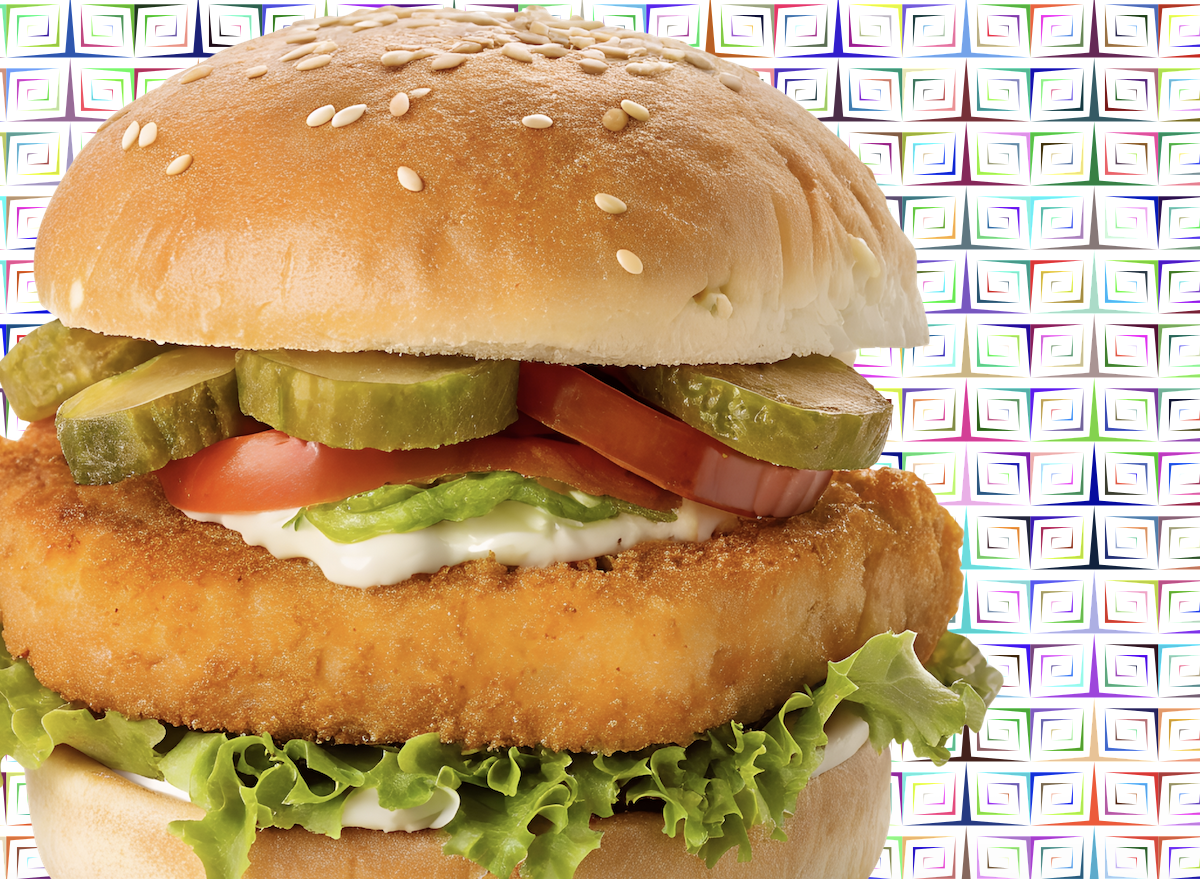 Filé de peixe dourado e crocante servido com salada fresca e rodelas de limão em um prato de cerâmica