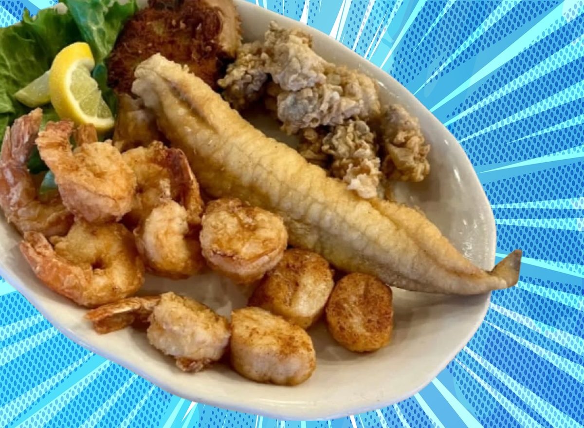 Um peixe frito crocante, com detalhes da textura dourada e fios de azeite espalhados