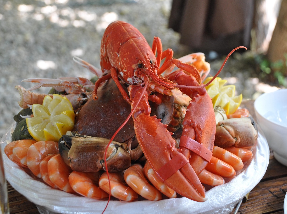 Um peixe frito firme e branco, com manchas douradas e um aroma suave, servido em um prato com folhas de alface e um lago ao fundo