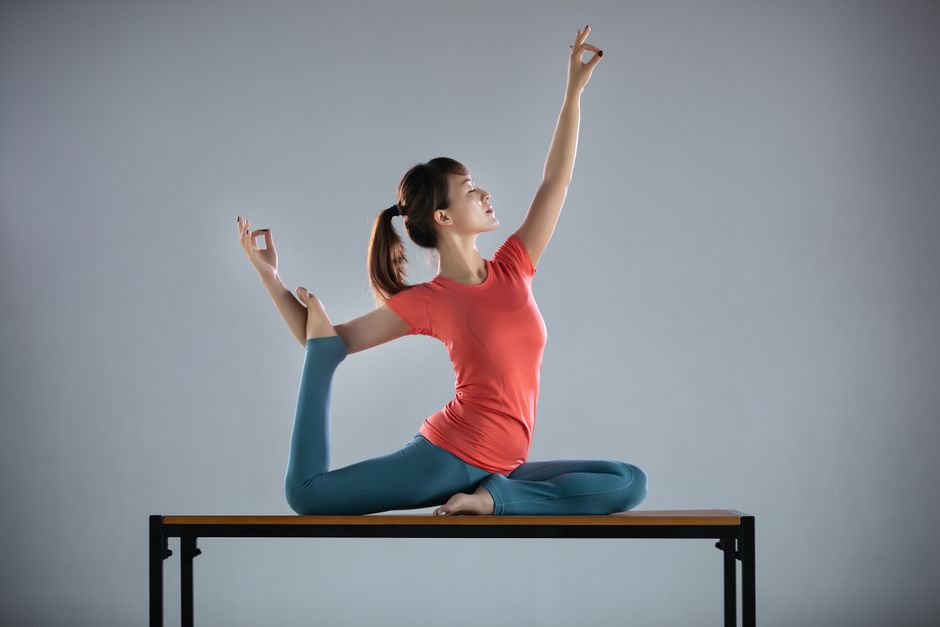 posturas de yoga de Phoenix Gisima, criança de 5 anos, em um tapete colorido ao lado de um bloco de espuma