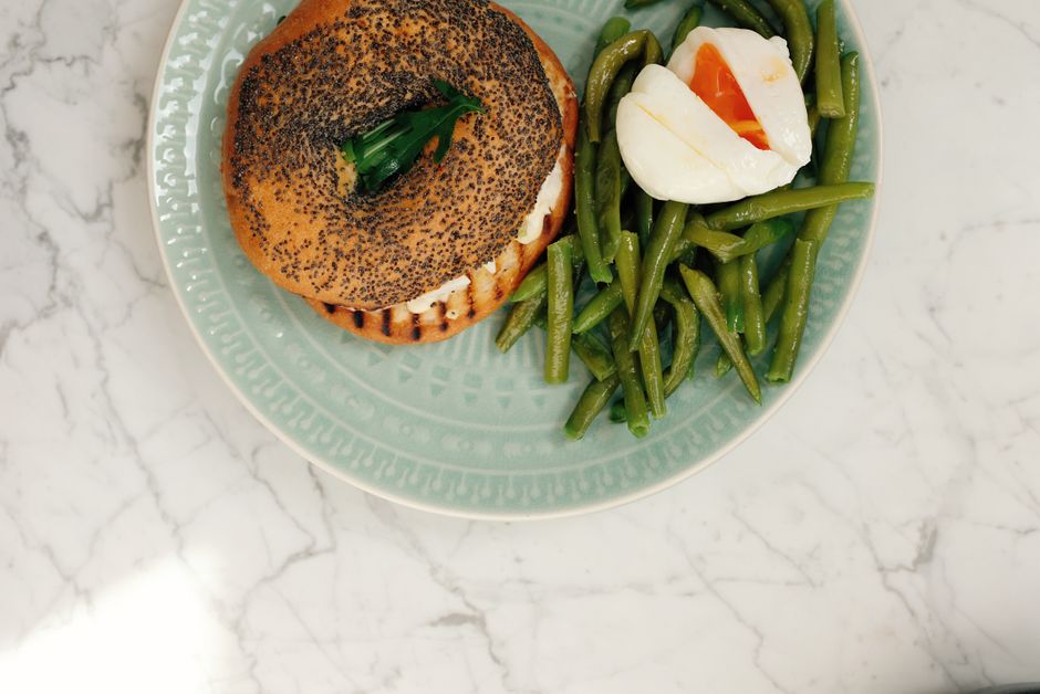 Bagels de iogurte recheados com mini‑pepperoni, muçarela derretida e molho de tomate ao lado de uma balança