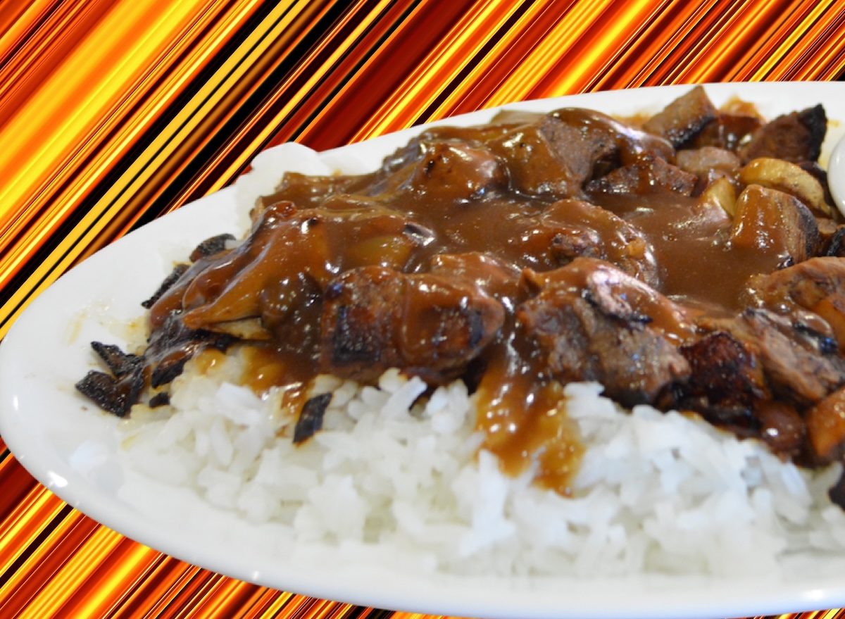 Prato com cubinhos de carne bovina cozidos em molho escuro, arroz branco solto e salsinha picada ao lado