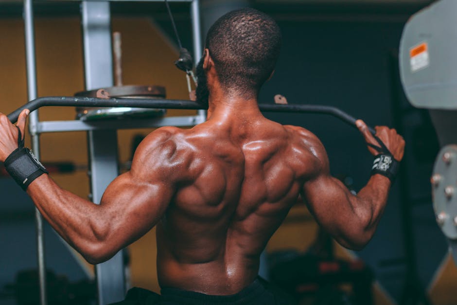 Uma pessoa realizando um pull-up com queixo acima da barra, segurando uma barra e apoiada em uma cadeira
