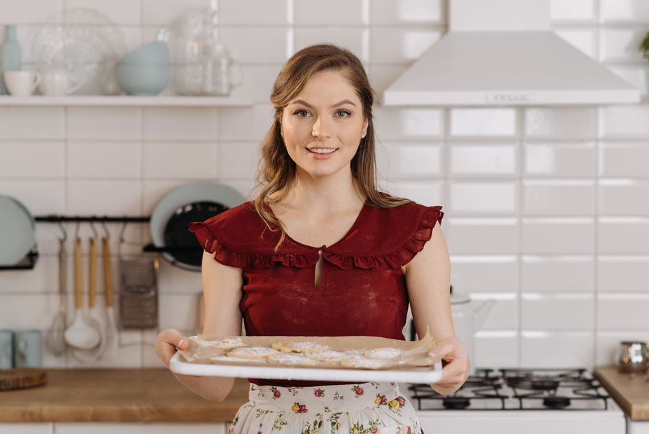 Cookie de abóbora dourado ao lado de uma air fryer aberta, com aveia, canela e uma colher de mel sobre a bancada