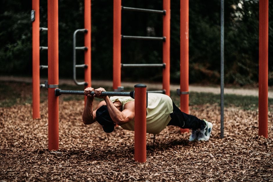 Uma mulher saudável, entre 55 e 60 anos, realizando uma série de push-ups com pernas afastadas e braços retos