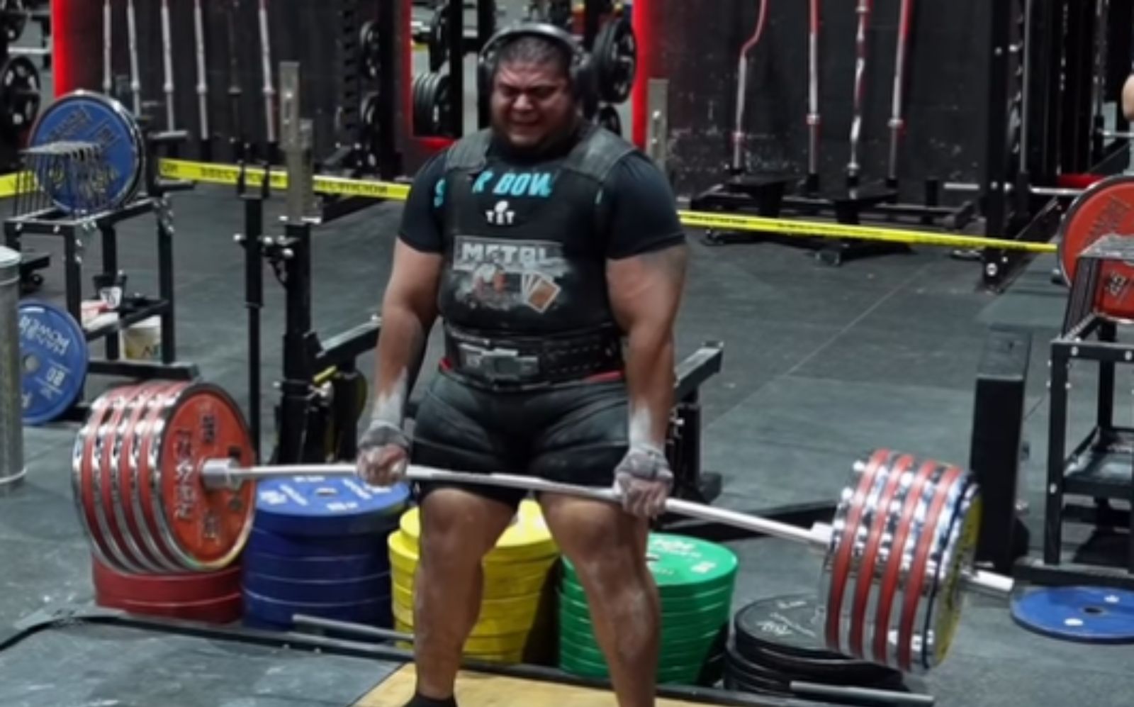 Atleta mexicano levantando barra pesada de 504 kg em academia, com halteres e placa de peso visíveis