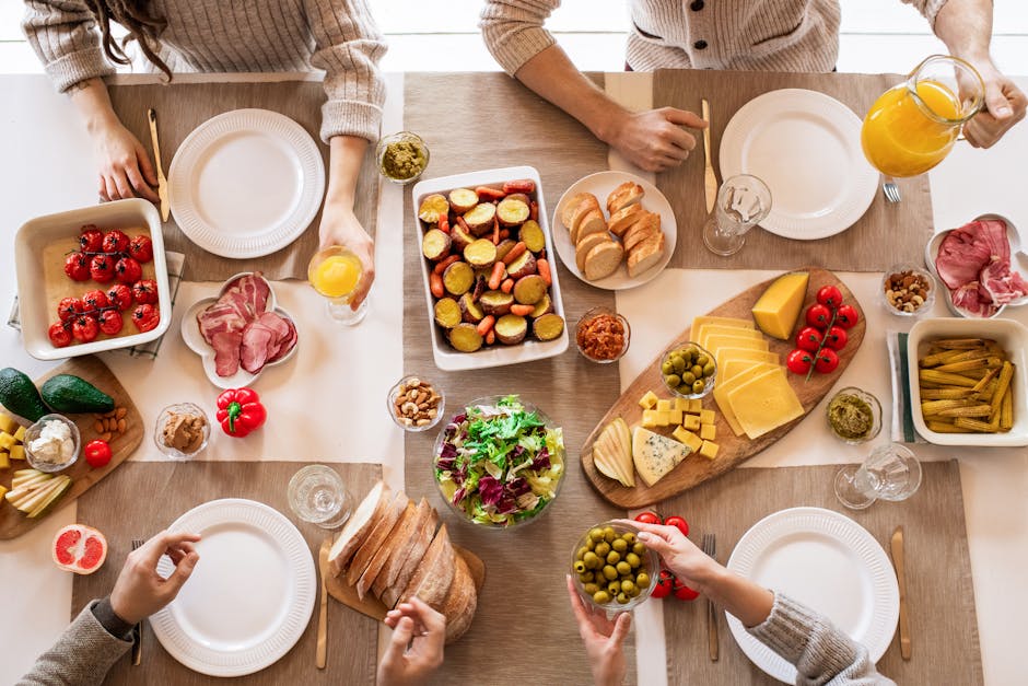 Mesa posta com torradas de abacate, frutas frescas, iogurte com granola e flores em ambiente iluminado e acolhedor