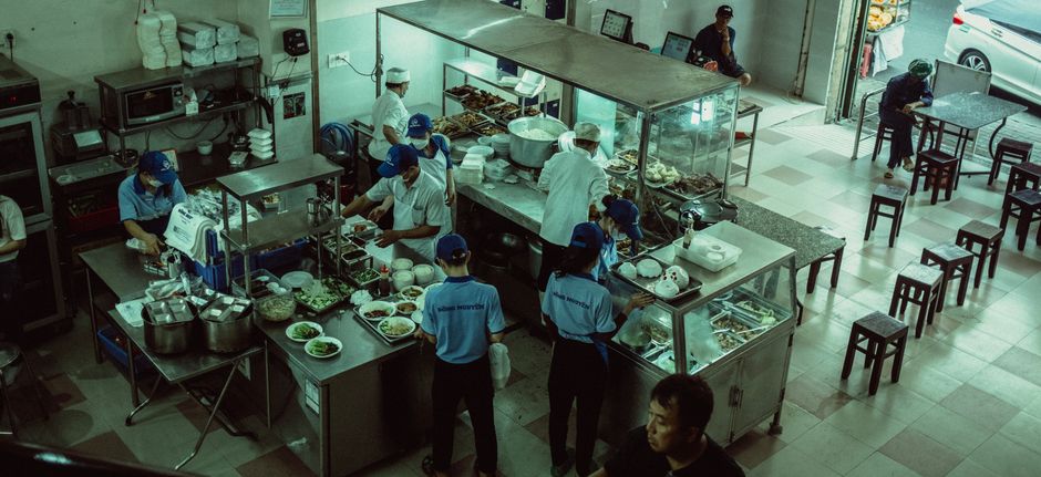 Um prato colorido de salada fresca ao lado de um certificado de licença sanitária pendurado na parede do restaurante
