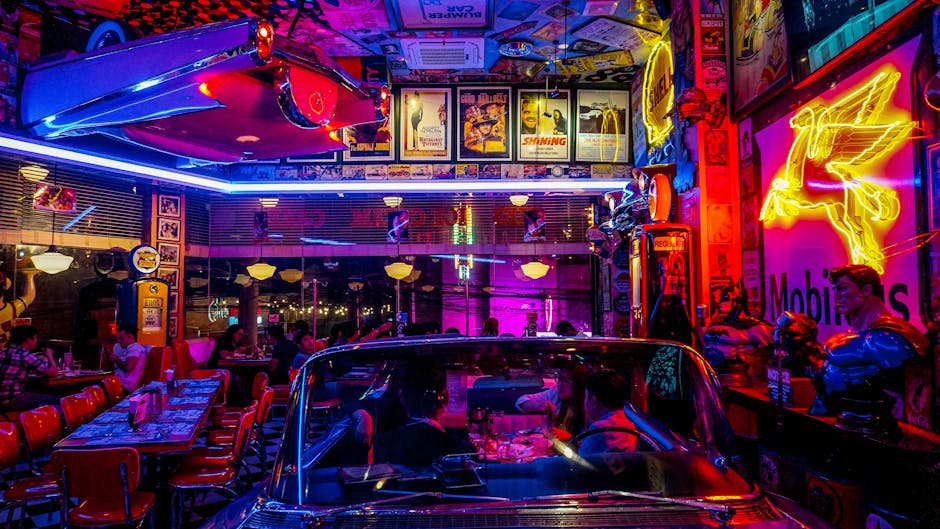 Hambúrguer suculento e milkshake servidos em balcão retrô com luzes neon e bancos de couro típicos de diners