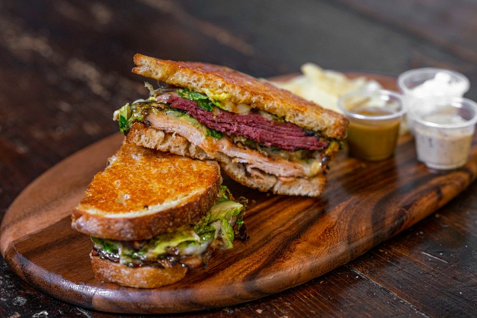 Um Reuben clássico sobre pão de centeio, com carne curada, queijo suíço e chucrute