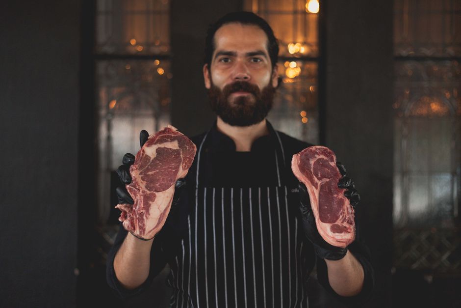 Bife ribeye suculento grelhado ao ponto, ao lado de folhas de espinafre e quinoa, destacando proteína e saúde