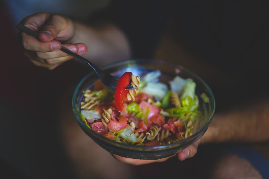 Salada colorida em bowl com molho cremoso ao lado, evidenciando ingredientes calóricos como bacon e queijo