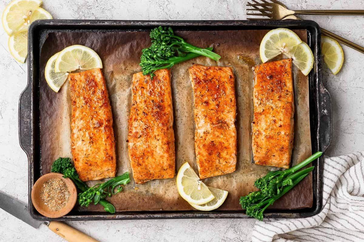 Um salmão assado ao forno, com óleo de abacate e tempero, em uma assadeira forrada