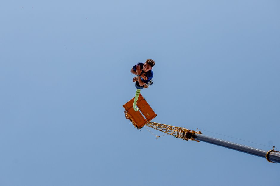 Jogador de basquete em salto vertical, medindo a altura com fita métrica ao lado de um aro de 10 ft