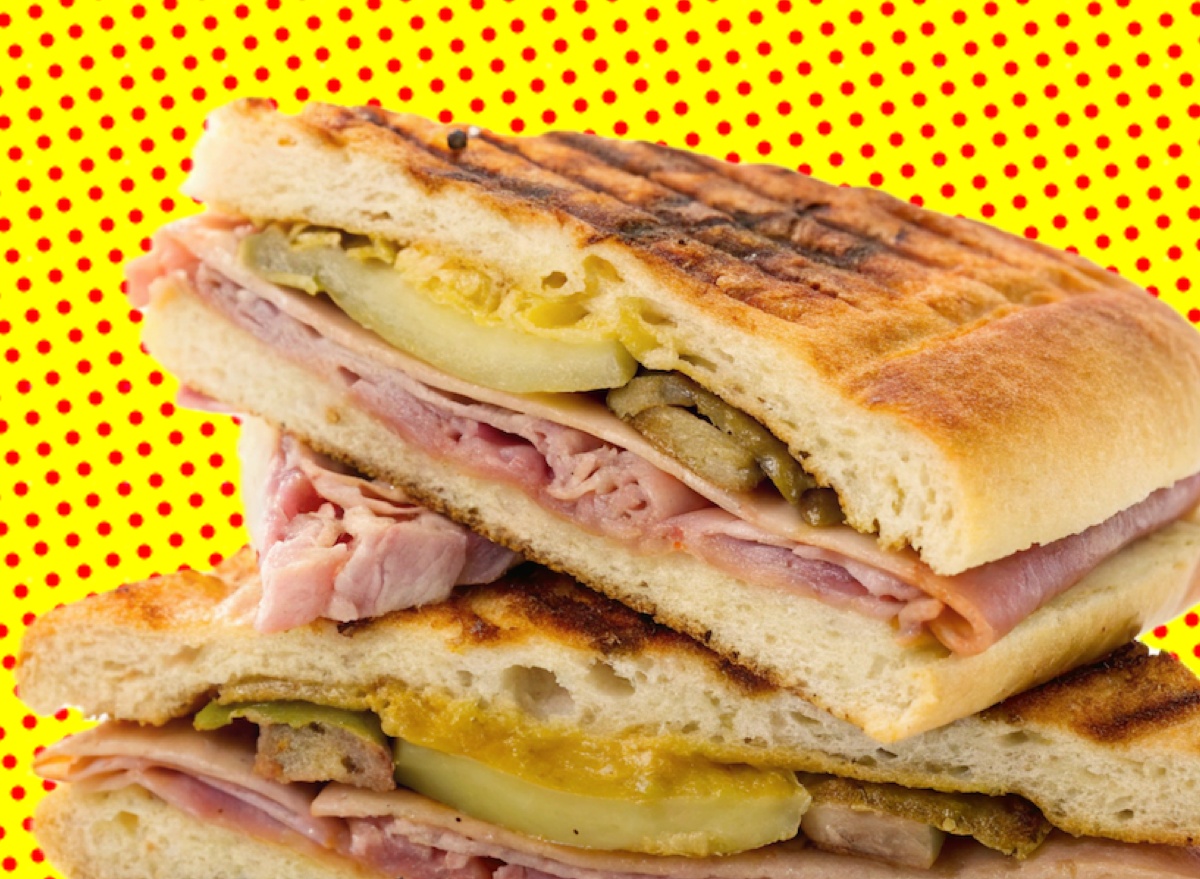 Um sanduíche cubano caseiro com camadas de carne de porco assada, presunto e queijo suíço