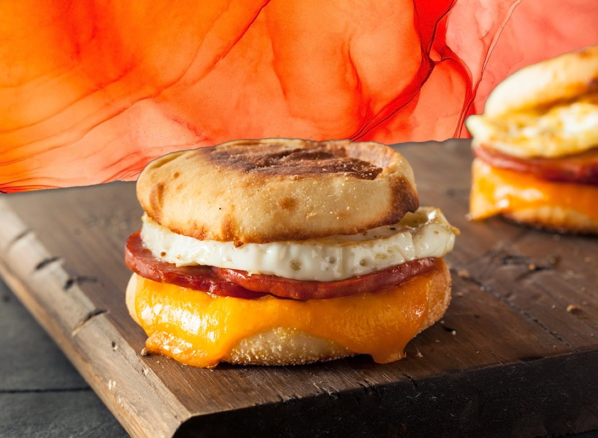 Uma mulher saudável segurando um sanduíche congelado de omelete com vegetais e frutas