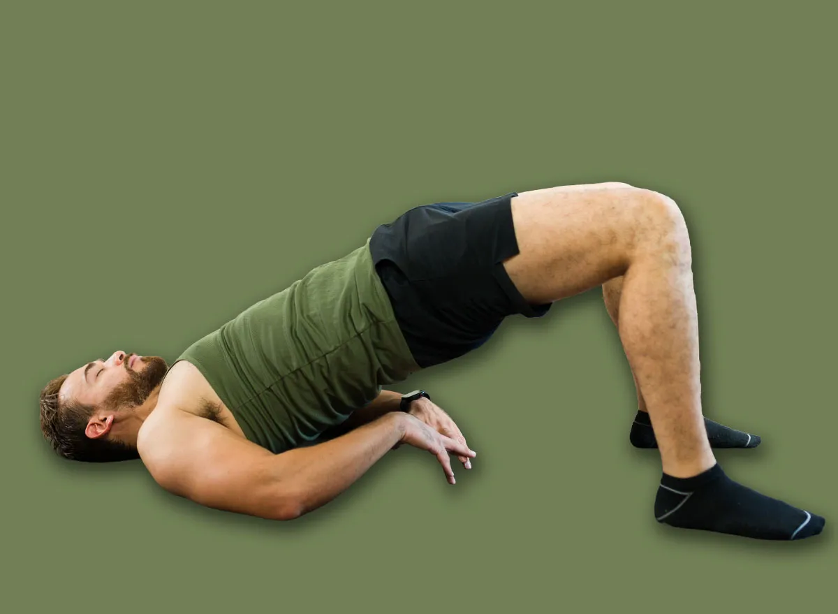 Homem de 60+ vestindo roupa esportiva, segurando kettlebell enquanto realiza goblet squat ao ar livre