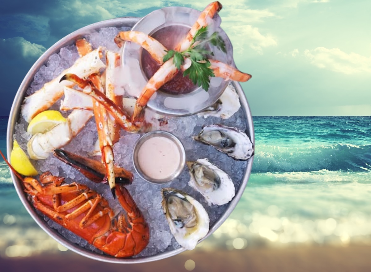Um prato de salmão grelhado ao lado de uma tigela de frutos do mar frescos e folhas de alface