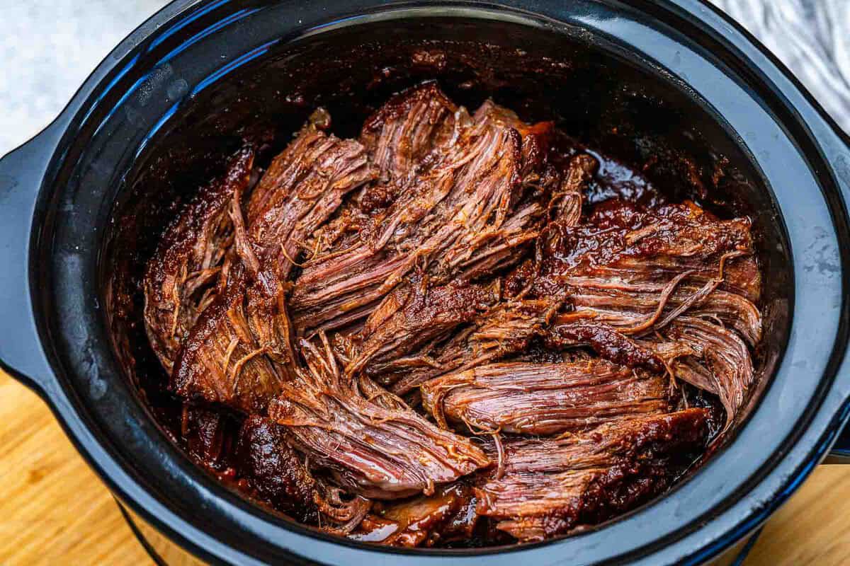 Chuck roast suculento ao molho barbecue ao lado de quinoa, brócolis cozido no vapor e fatias de abacate