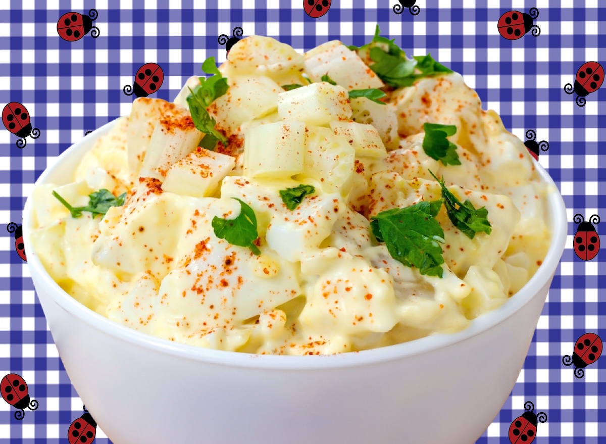 Salada de batata em pote plástico sobre mesa de churrasco, ao lado de um rótulo nutricional em destaque