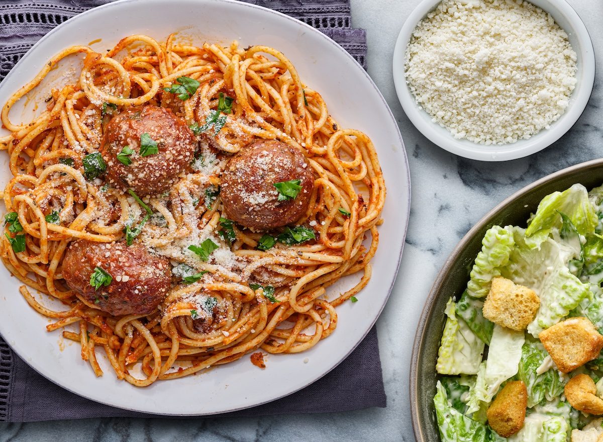 Prato com spaghetti integral, almôndegas magras ao molho de tomate fresco e salada Caesar de alface, parmesão e croutons crocantes
