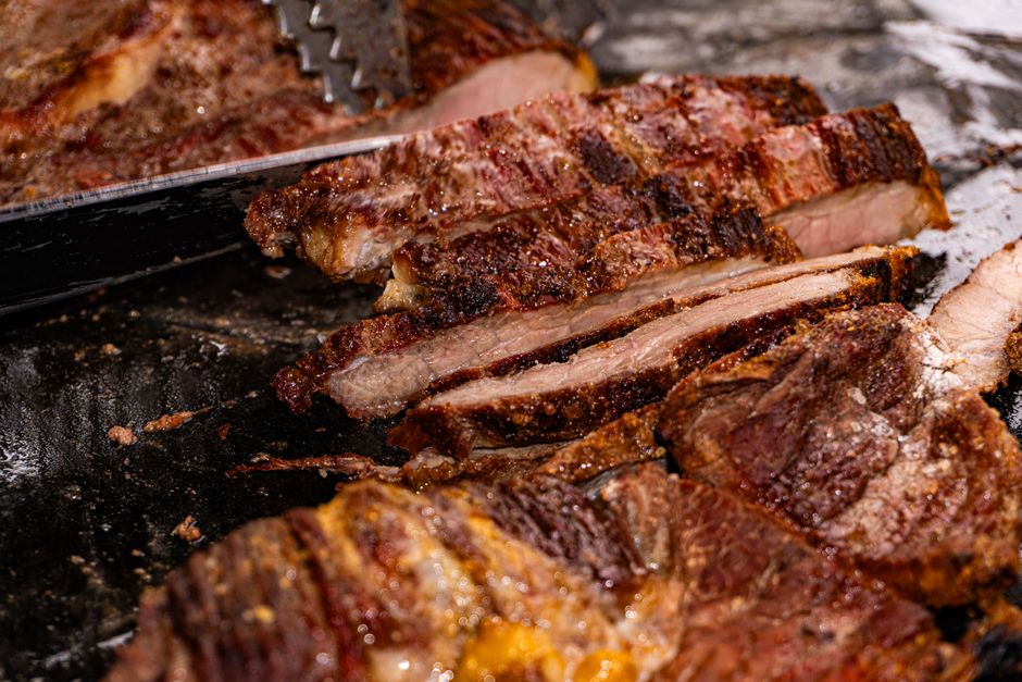 Filé mignon grelhado suculento ao lado de uma tábua com sal grosso, azeite e legumes assados