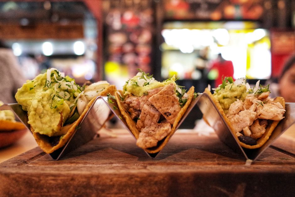 Tortilhas de milho recheadas com frango grelhado, abacate e pimentões coloridos, ao lado de uma garrafa de água e um cronômetro