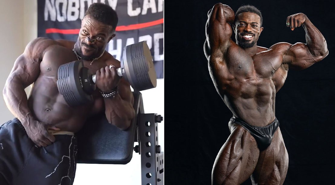 Terrence Ruffin executa rosca direta com barra, braços flexionados, vestindo regata preta e luvas de treino