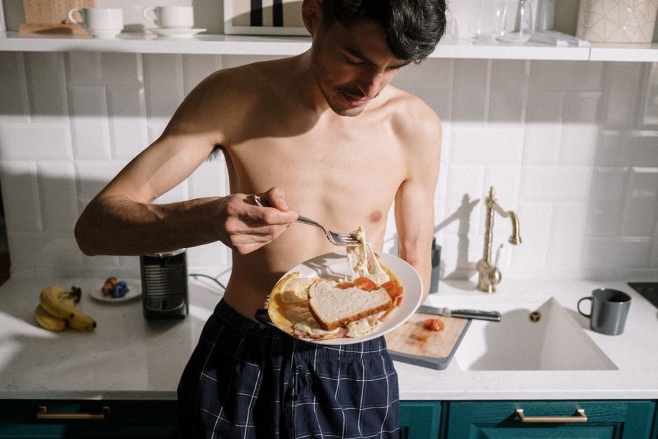 Atleta segurando uma lata de tomate ao lado de halteres, com foco no rótulo que destaca licopeno e vitamina C