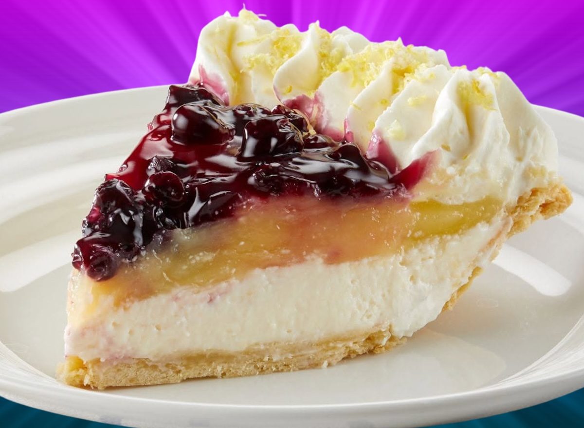 Fatia de torta de maçã caseira ao lado de uma maçã inteira, um rolo de massa e uma fita métrica enrolada