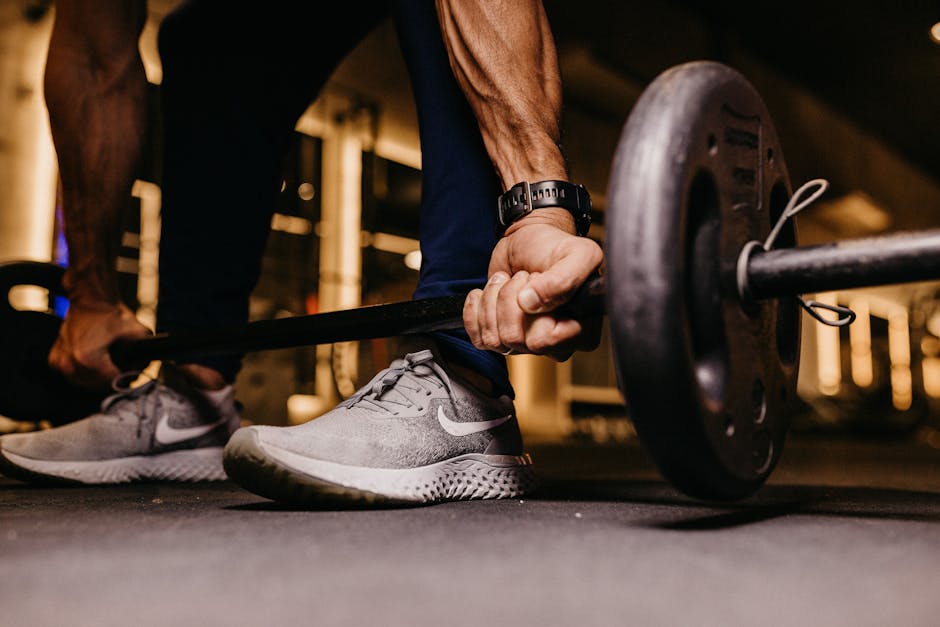 Uma pessoa realizando exercícios de força com halteres e elástico em uma sala de treino
