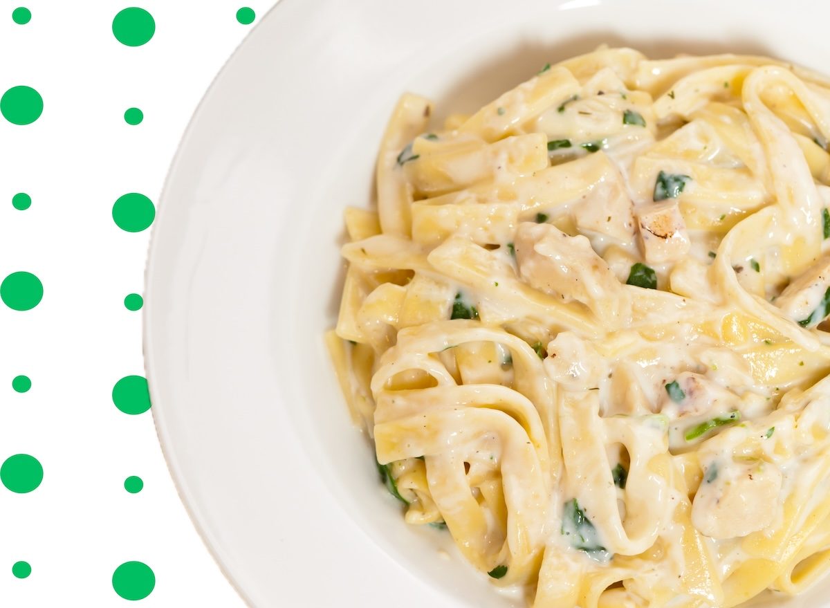 Pasta al dente coberta com molho cremoso e frango suculento em uma panela